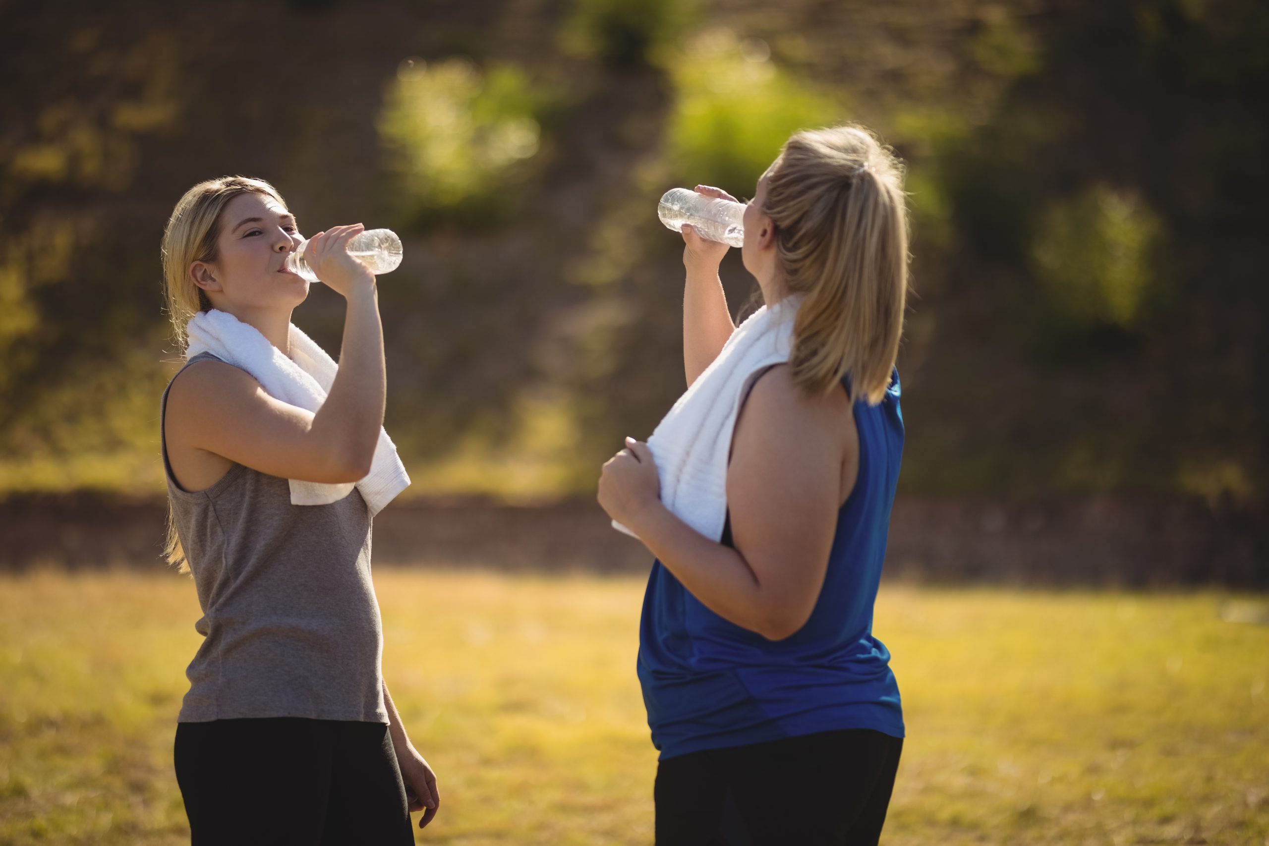 Two women drinking water outdoors during Dry January, representing healthy lifestyle choices and liver health awareness.